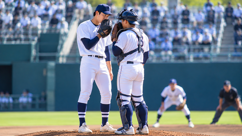 大学野球のマウンドで作戦を確認する投手と捕手をイメージしたイラスト